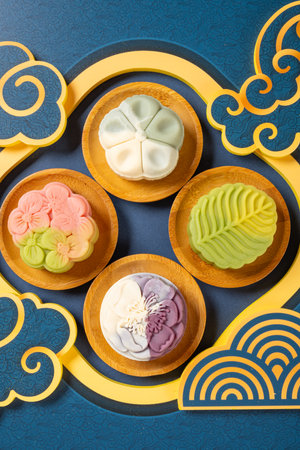 top view trendy different flower shapes mooncakes on blue background at vertical composition