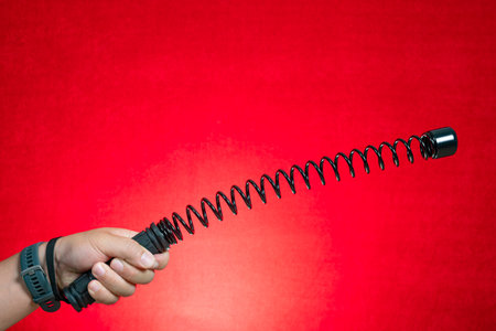 hand with an arm exerciser bar on redの写真素材