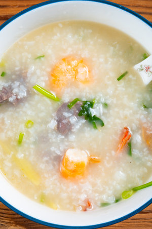 top view fresh shrimps and beef porridge at vertical composition