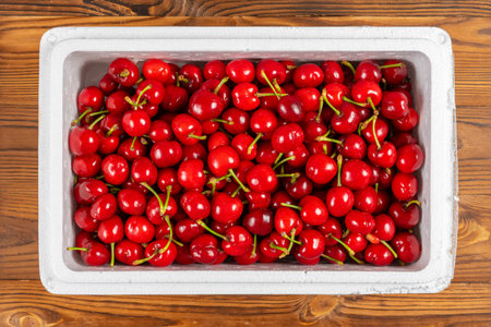 top view fresh cherries in a box at horizontal composition