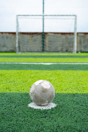 an old soccer on the penalty spot on a soccer field at vertical compositionの写真素材
