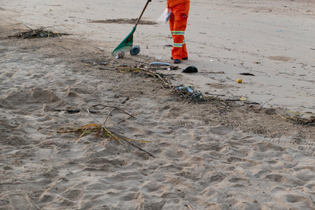 sanitation worker picking up trash on the beachの写真素材