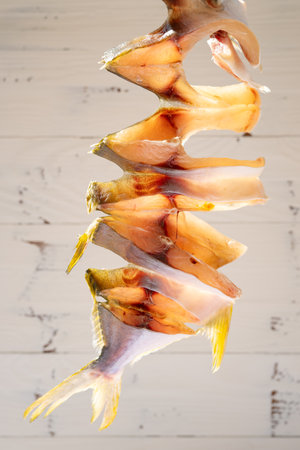 raw fishes being air dried on a balcony vertical composition