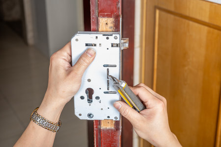 man installing a lock to the doorの写真素材