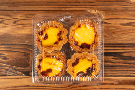 top view box of portuguese egg tarts on a wooden table at horizontal composition
