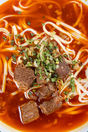 top view spicy beef noodles with soup at vertical composition