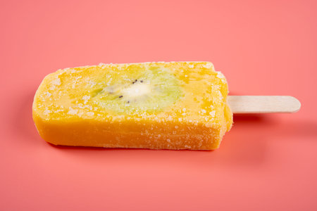 fresh mango and milk flavor popsicle with slice of kiwi fruit on pink