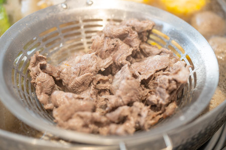 tender beef on a strainer being cooked in the pot