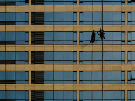 Two men clean the high-rise building which is a very dangerous work.のeditorial素材