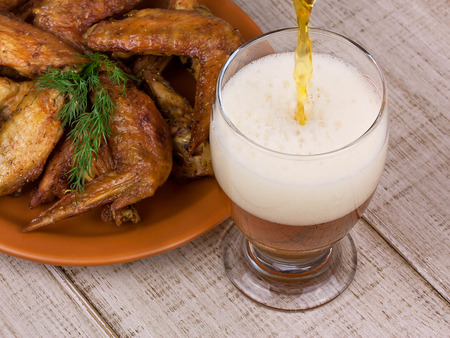 Beer and chicken wings on wooden backgroundの写真素材