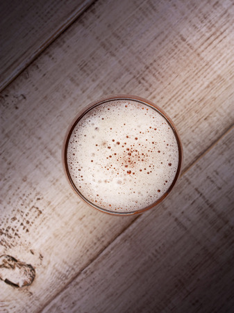 Glass of beer over wooden background, top shotの写真素材