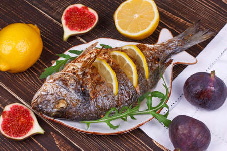 Whole grilled fish dorado served with lemon and figs;の写真素材