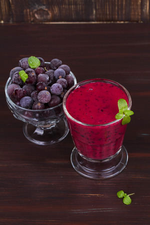 Frozen black currant berries smoothie with mintの写真素材