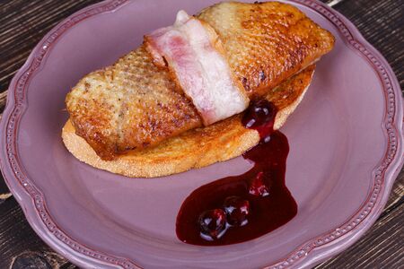 Roasted duck breast fillet with bacon, black currant and wine sauceの写真素材