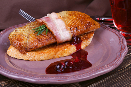 Roasted duck breast fillet with bacon, black currant and wine sauceの写真素材