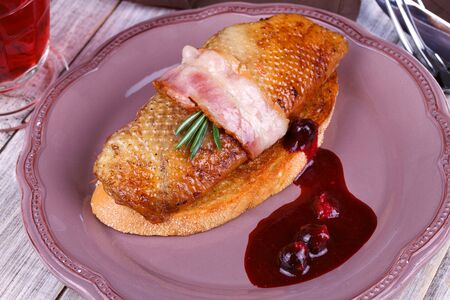 Roasted duck breast fillet with bacon, black currant and wine sauceの写真素材