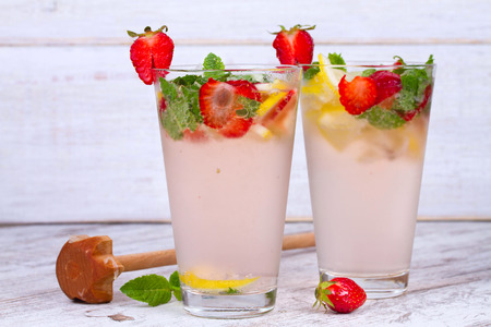Lemonade with fresh strawberries mint and lemon on wooden backgroundの写真素材