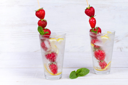 Lemonade with fresh strawberries mint and lemon on wooden backgroundの写真素材