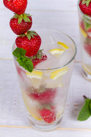 Lemonade with fresh strawberries mint and lemon on wooden backgroundの写真素材
