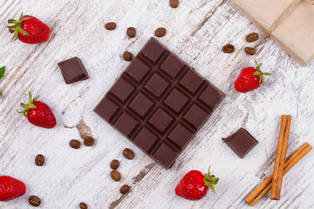 Chocolate bars and strawberries on wooden backgroundの写真素材