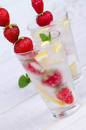 Lemonade with fresh strawberries mint and lemon on wooden backgroundの写真素材