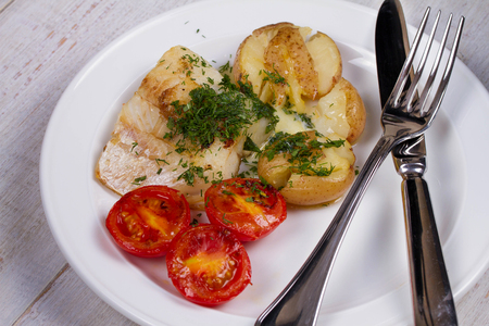 Fish Fillets with Herbs, Crispy Potatoes and  Roasted Tomatoesの写真素材