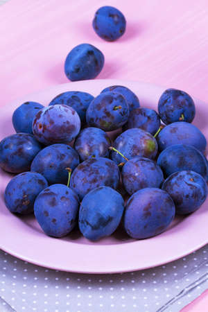Fresh plums on pink plateの写真素材