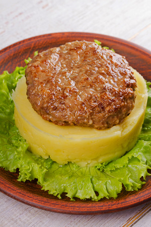 Beef and pork patty with smashed potato and lettuceの写真素材