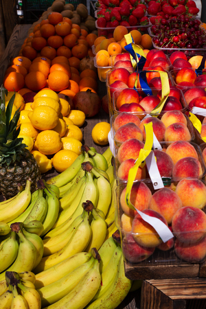 Apples, lemons, oranges, pomegranates, pineapples, peaches and strawberry. Various fruits in a street marketの写真素材