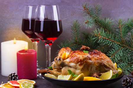 Festive Christmas turkey baked with orange, lemon and lime. Glasses of red wine and candlesの写真素材