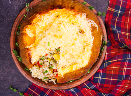 Stuffed pumpkin with meat, rice, mushrooms,  pepper and thyme. Baked butternut squash with rice. View From Above, Top Studio Shotの写真素材