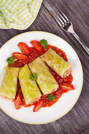 Cabbage rolls with meat, rice and vegetables in tomato sauce. Stuffed cabbage leaves with meat. Dolma, sarma, sarmale, golubtsy or golabki - traditional and popular dish in many countries. View from above, top studio shotの写真素材