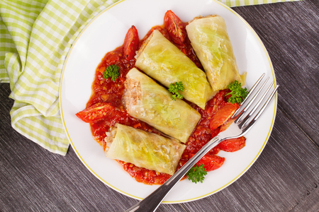 Cabbage rolls with meat, rice and vegetables in tomato sauce. Stuffed cabbage leaves with meat. Dolma, sarma, sarmale, golubtsy or golabki - traditional and popular dish in many countries. View from above, top studio shotの写真素材