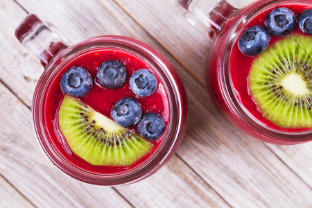 Berry kiwi smoothie in the jars. View from above, top studio shotの写真素材