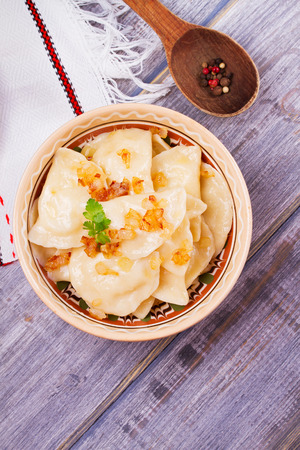 Varenyky, vareniki, pierogi, pyrohy or dumplings, filled with potato and served with salty caramelized onion. View from above, top studio shot, overheadの写真素材