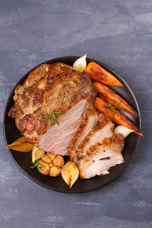 Roasted sliced ham with vegetables on grey rustic background, view from above, top, verticalの写真素材
