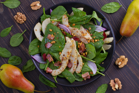 Spinach pear and bacon salad with walnutsの写真素材