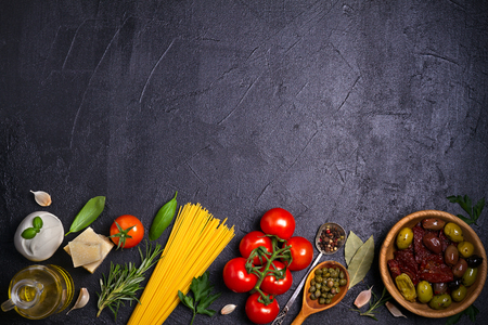 Selection of healthy food. Italian food background with spaghetti, mozzarella parmesan cheese, olives, tomatoes and rosemary. Vegetarian food banner. overhead, horizontalの写真素材
