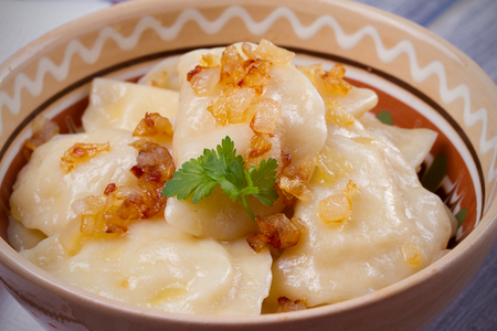 Dumplings, filled with mashed potato - vegetarian dish. Varenyky, vareniki, pierogi, pyrohy in a bowl on wooden table. horizontalの写真素材