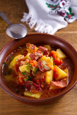 Goulash soup bograch in a bowl. Hungarian dish. Stew, made with beef, bacon, sausages, potatoes and carrotsの写真素材