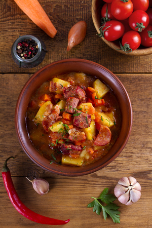Goulash soup bograch in a bowl. Hungarian dish. Stew, made with beef, bacon, sausages, potatoes and carrots. View from above, top studio shotの写真素材