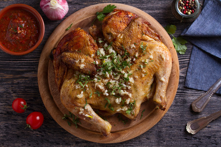 Roasted chicken with garlic on wooden tray. View from above, topの写真素材