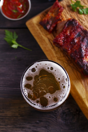 Beer and pork spare ribs. Beer and meat. Glass of ale. View from above, top studio shotの写真素材