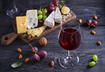 Red wine with cheese on chopping board. Wine and food concept - Imageの写真素材