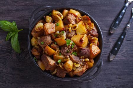 Tasty food: succulent beef with fried potatoes, onion and garlic. Country-style roasted potatoes with meatの写真素材