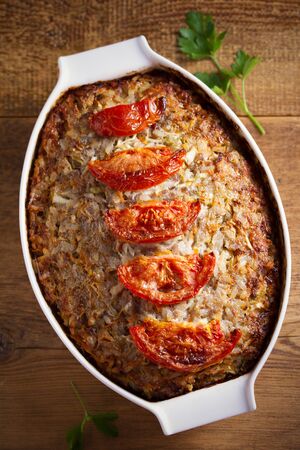 Beef rice and cabbage casserole in white baking dish on wooden table の写真素材
