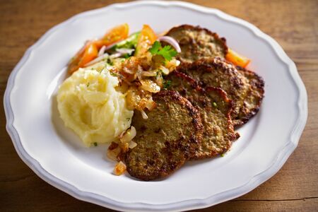Chicken liver pancakes with mashed potato and vegetables on white plate. Liver side dishの写真素材