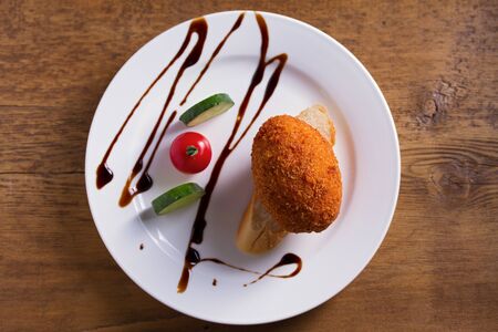Chicken Kiev and vegetables. Breaded chicken breast stuffed with herbs and butter. View from above, top studio shotの写真素材