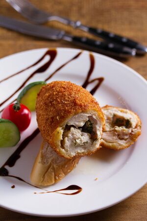 Chicken Kiev and vegetables. Breaded chicken breast stuffed with herbs and butterの写真素材