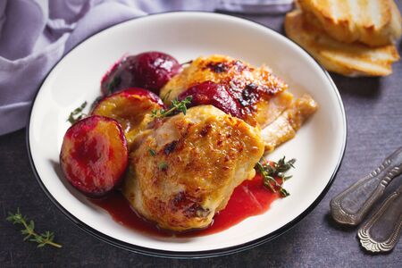 Baked chicken and plums in ginger, honey and red wine sauce with thyme. Horizontal imageの写真素材
